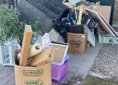Boxes, storage bins, and household items set out for removal during a home cleanout